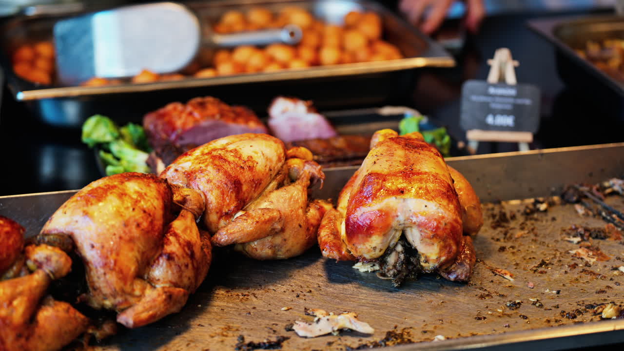 Close up of multiple grilled chickens at a food stand