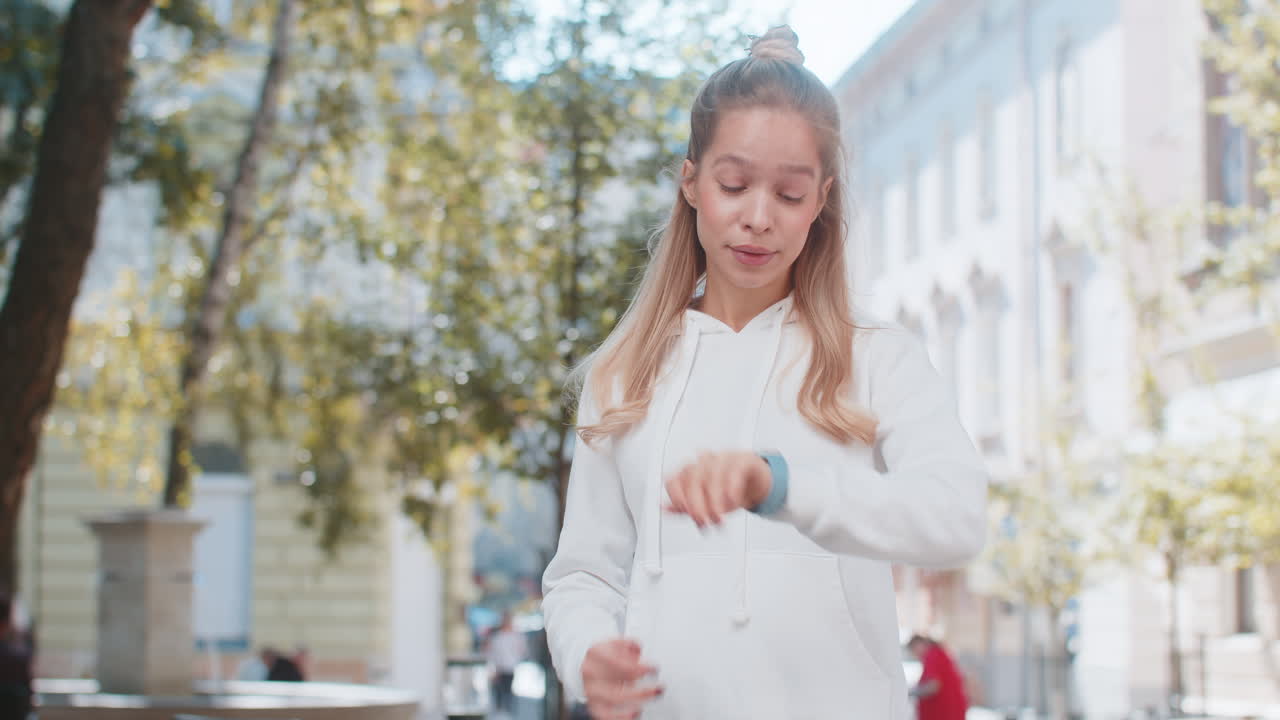 Young woman worrying to be punctual with anxiety checking time on watch running late to transport