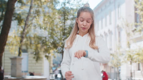 young woman worrying to be punctual with anxiety checking time on watch running late to transport