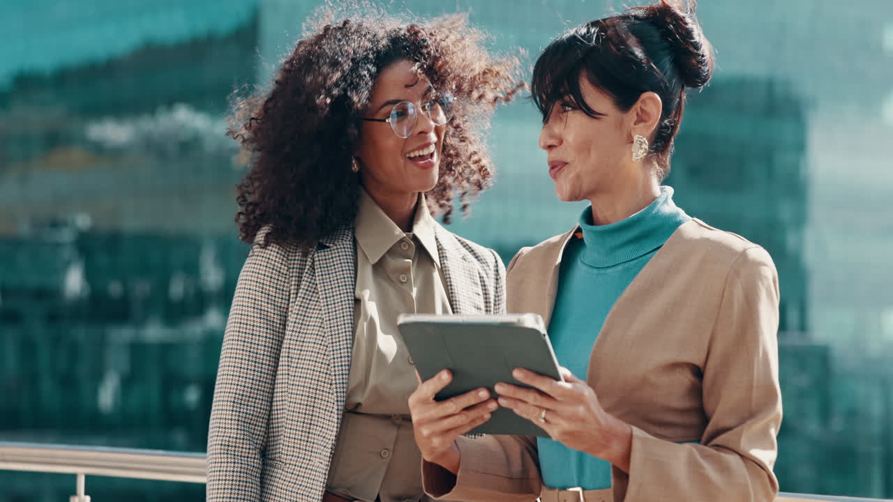 Business women celebrating success with tablet outdoors