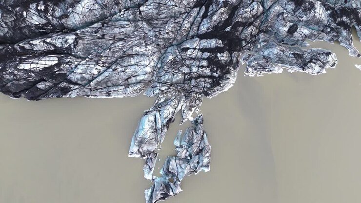 Top down aerial view of melting icy rocky glacier landscape in Iceland