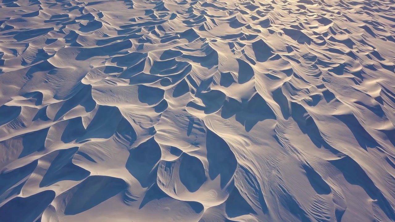 Aerial View of Wind-Swept Snow Dunes in Arctic Landscape