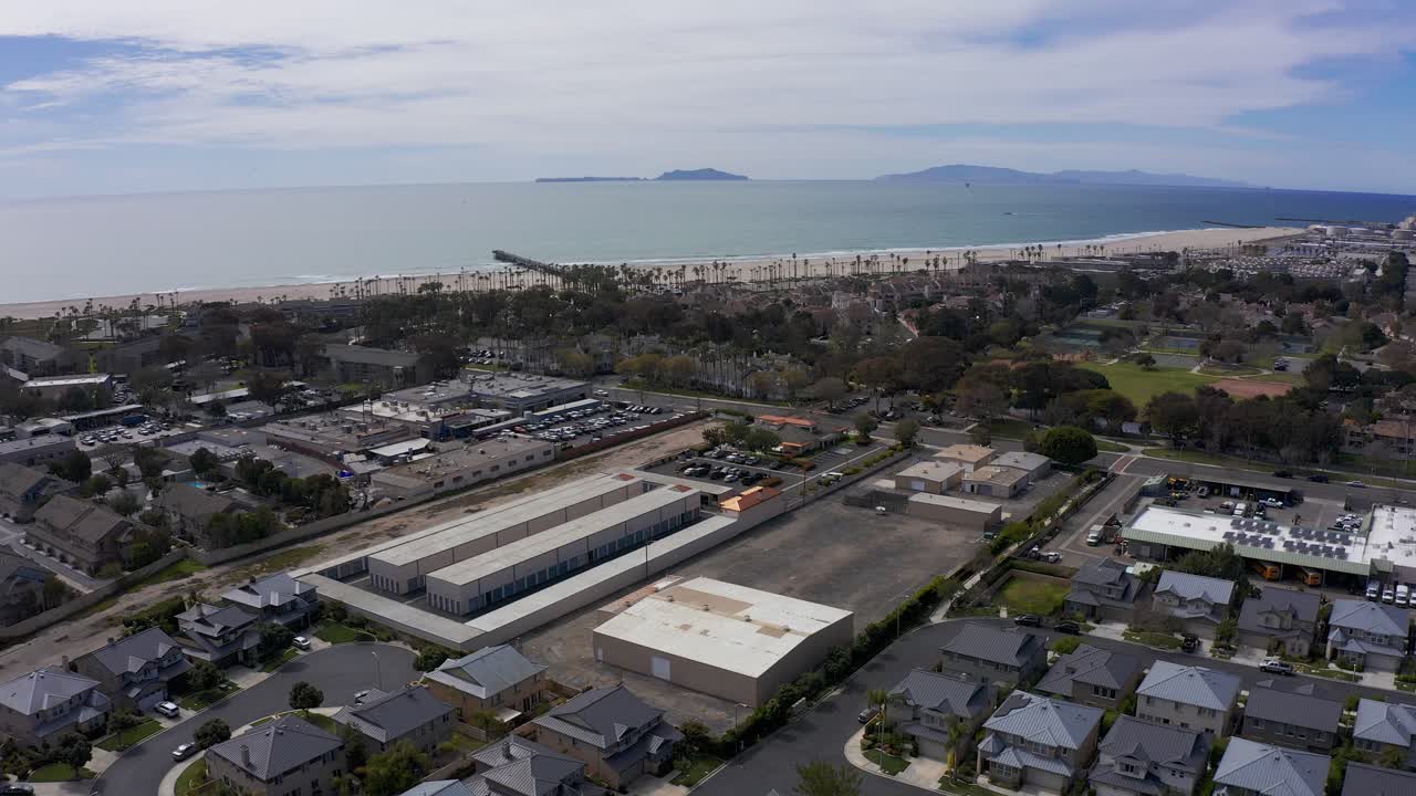 tomada aérea descendente de un parque industrial en port hueneme con el océano pacífico en el fondo
