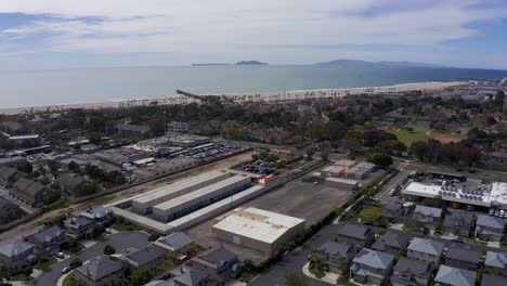 Toma-Aérea-Descendente-De-Un-Parque-Industrial-En-Port-Hueneme-Con-El-Océano-Pacífico-Al-Fondo