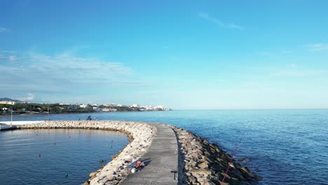 aerial drone views from a jetty on a beach in southern spain at sunset