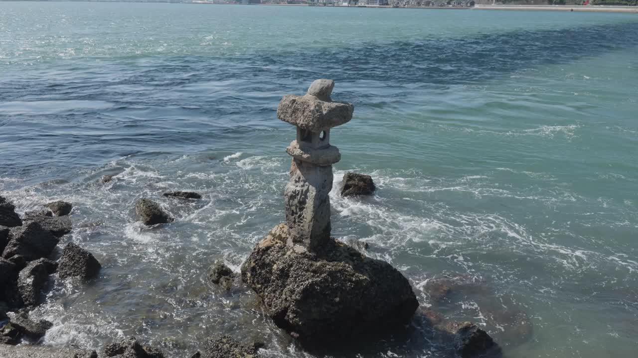 Stone statue on a stone in the sea, Kitakjushu, Kanmon Bridge, Japan