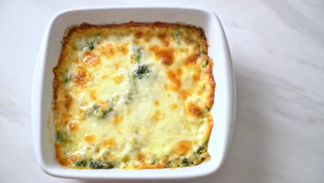 baked spinach lasagna with cheese in white plate