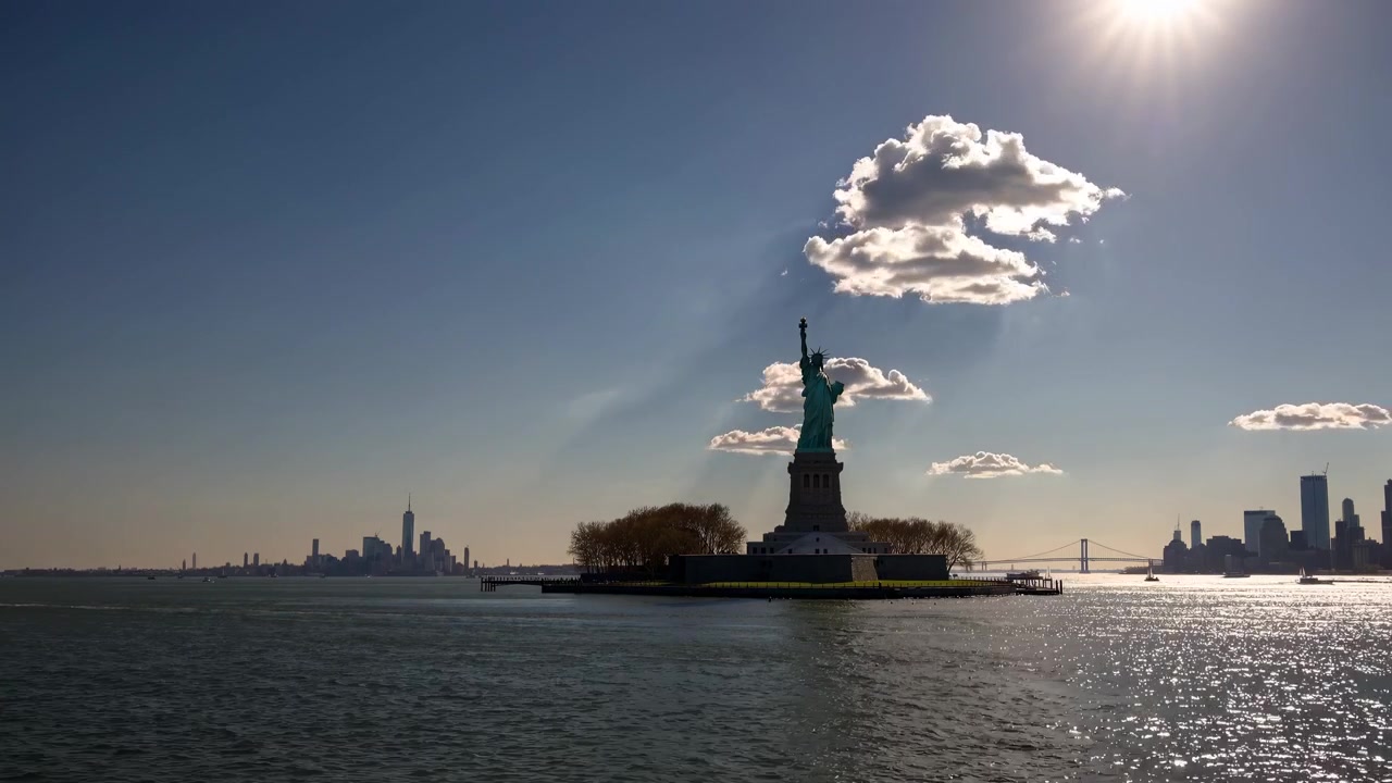 Frihedsgudinden i New Yorks havn ved solnedgang