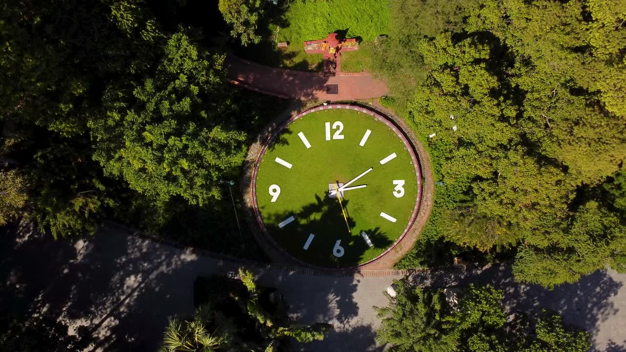 el icónico reloj gigante de wat phnom rodeado de exuberante vegetación, vista aérea