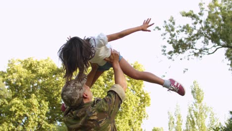 Military-dad-in-camouflage-clothes-playing-airplane