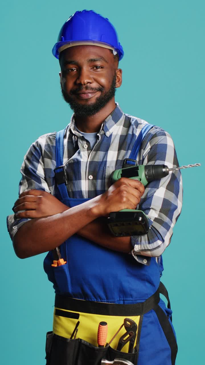 Vertical video: Construction worker posing with power drill gun