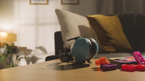 defensores de oído y rompecabezas de forma entrelazada en la mesa en casa para un niño diagnosticado con tea