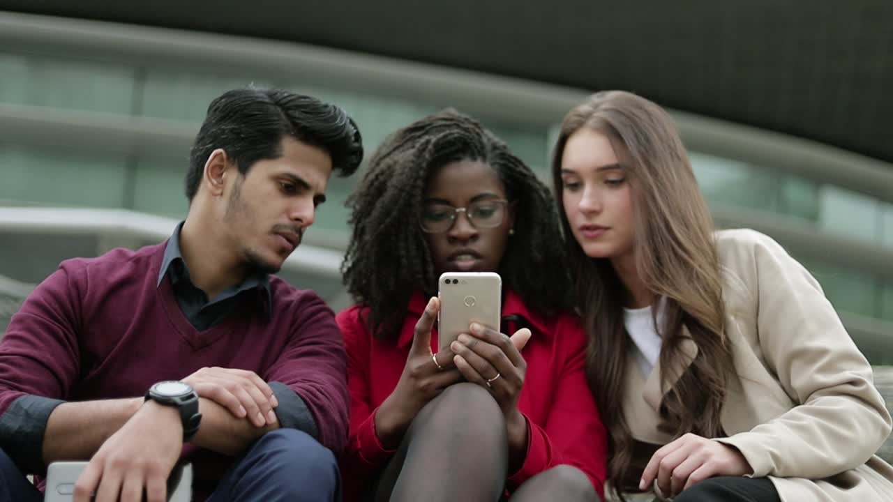 jóvenes buscando en google por teléfono dónde ir, discutiendo