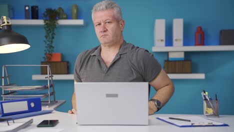 Home-office-worker-man-looks-at-camera-with-happy-and-smiling-face.