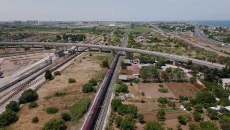 Imágenes-Aéreas-De-Un-Tren-De-Pasajeros-Que-Se-Aleja-Del-Pueblo-De-Bari,-Italia