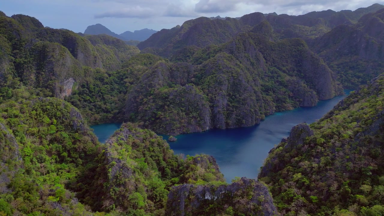 Água turquesa do Lago Kayangan, uma lagoa escondida cercada por imponentes carstes de calcário cobertos por vegetação verde exuberante. Vista aérea mágica, panorama de drone de cima.
