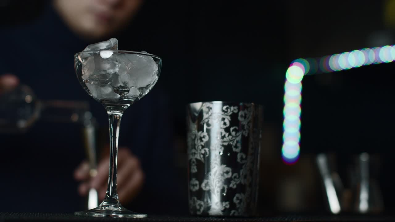 Barman che prepara un cocktail con ghiaccio e uno shaker