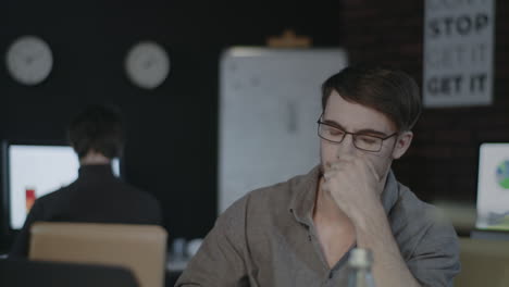 upset business man looking laptop at workplace in dark office.