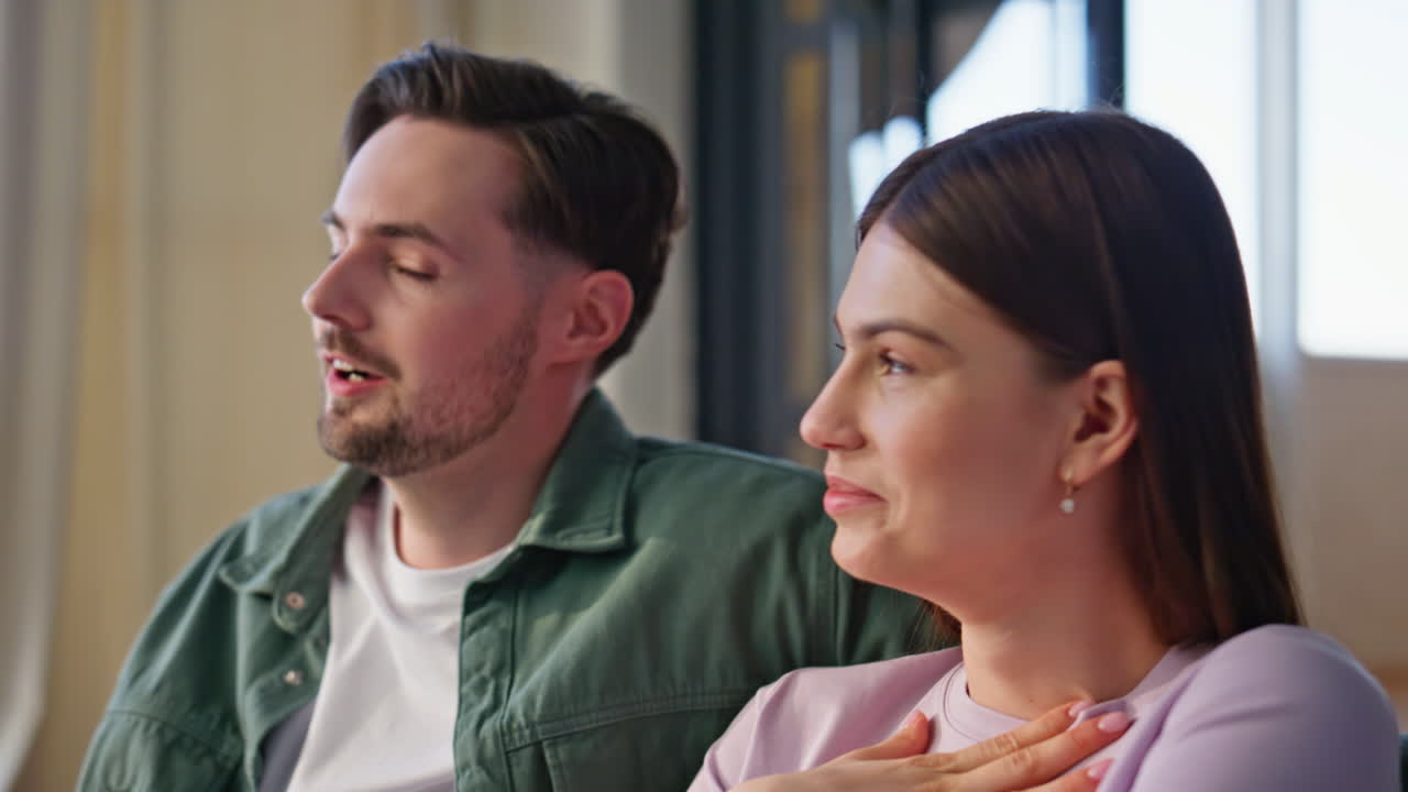 Involved pair watching horror movie at home closeup. Nervous couple looking tv