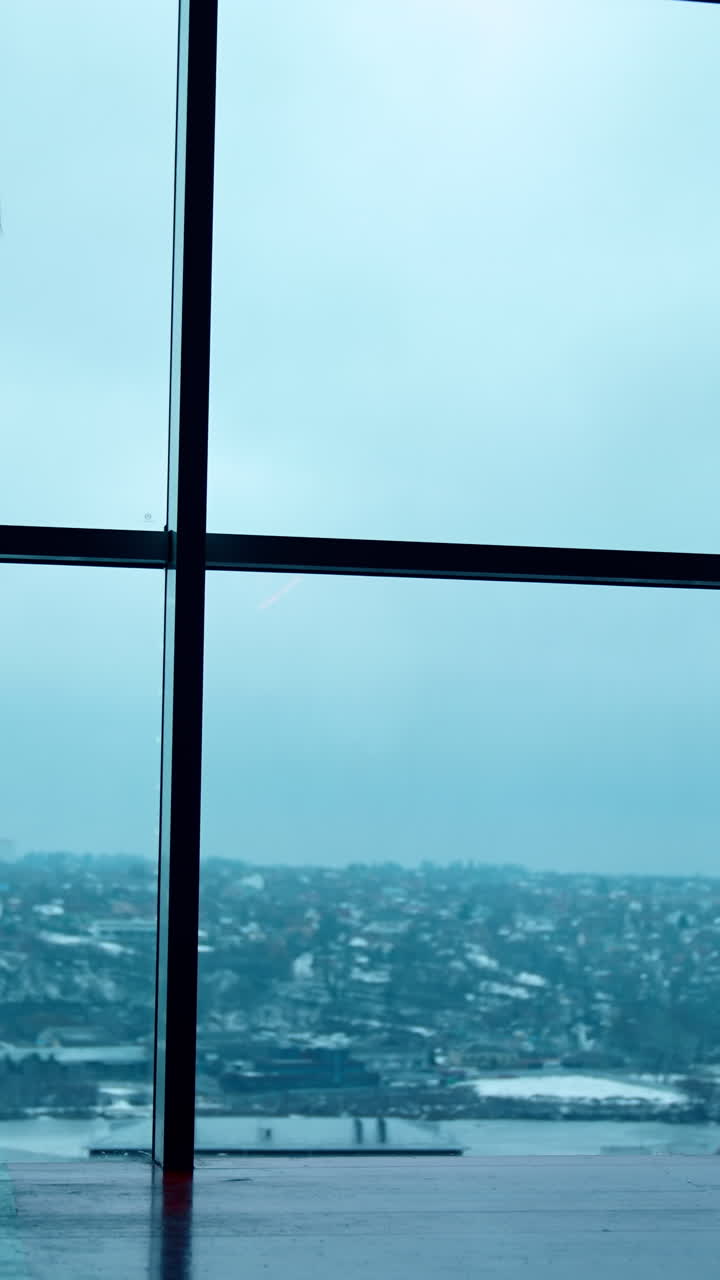 Silhouette of a girl in suit walking along the panoramic window