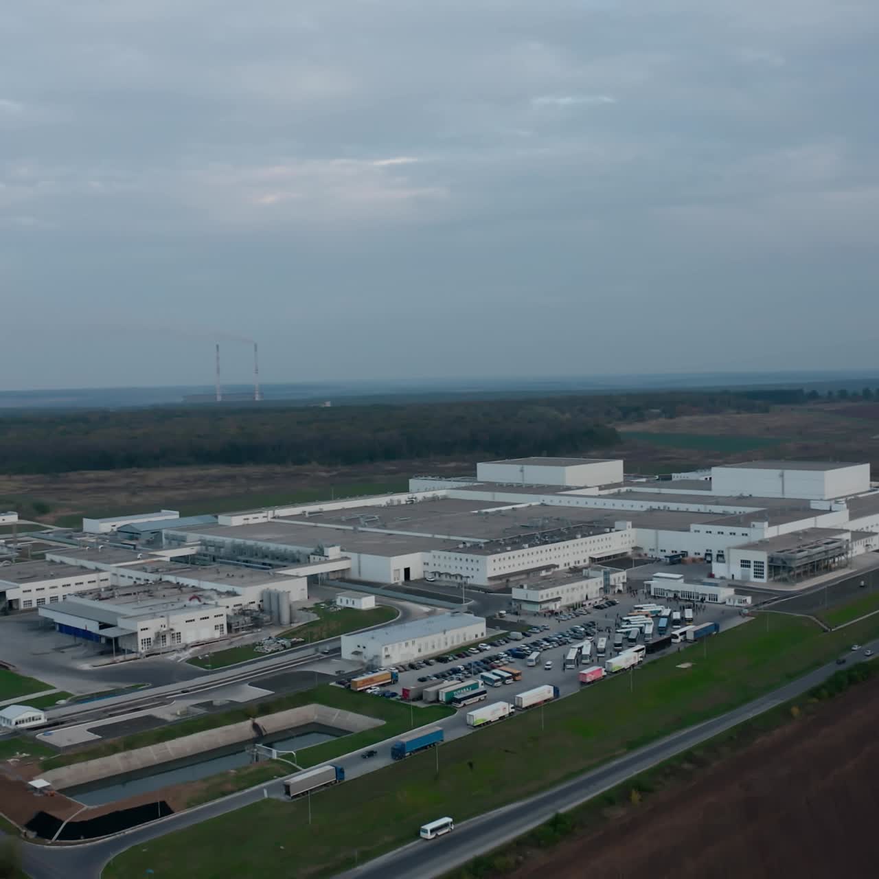 Modern industrial plant in the countryside. Industrial zone on nature landscape. Cars moving on the road. Aerial view.