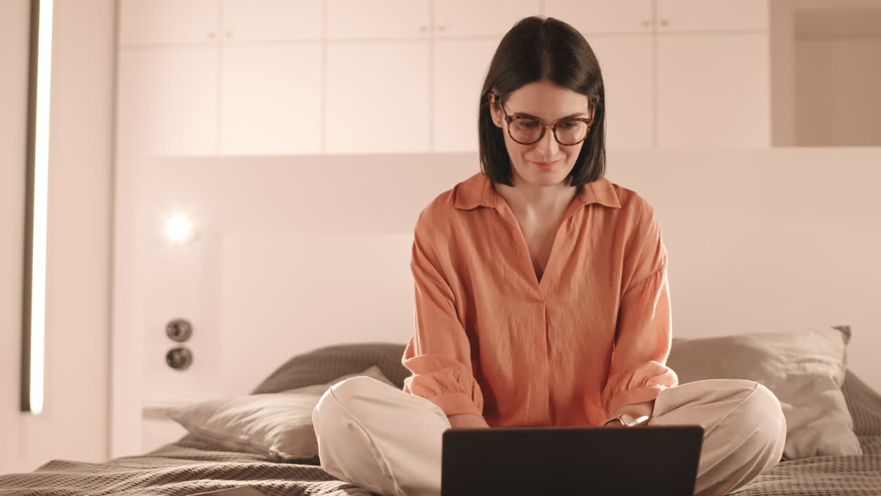 Woman Sitting on Bed Talking on Phone
