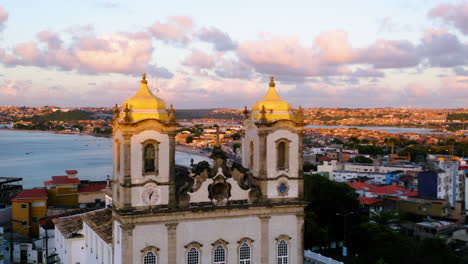 Aerial-view-of-the-top-of-Nosso-Senhor-do-Bonfim-church,-the-city-around-and-the-ocean-at-background,-Salvador,-Bahia,-Brazil