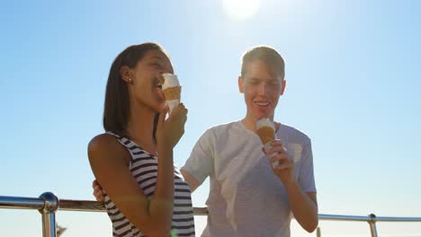 una joven pareja feliz tomando helado cerca de las barandillas 4k