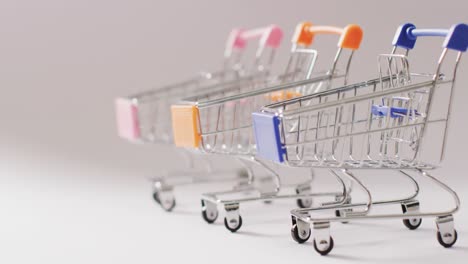 tres carretillas de compras vacías en un fondo gris sin costuras