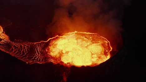 High-angle-view-of-hot-magma-eruption-in-active-volcano-crater.-Boiling-molten-material-flowing-out.-Fagradalsfjall-volcano.-Iceland,-2021