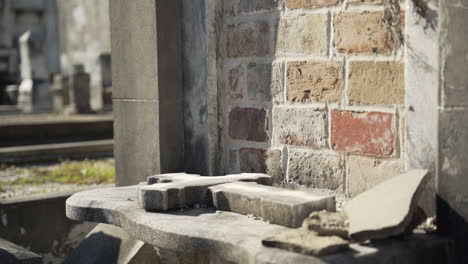 una cruz de piedra está al lado de una vieja tumba