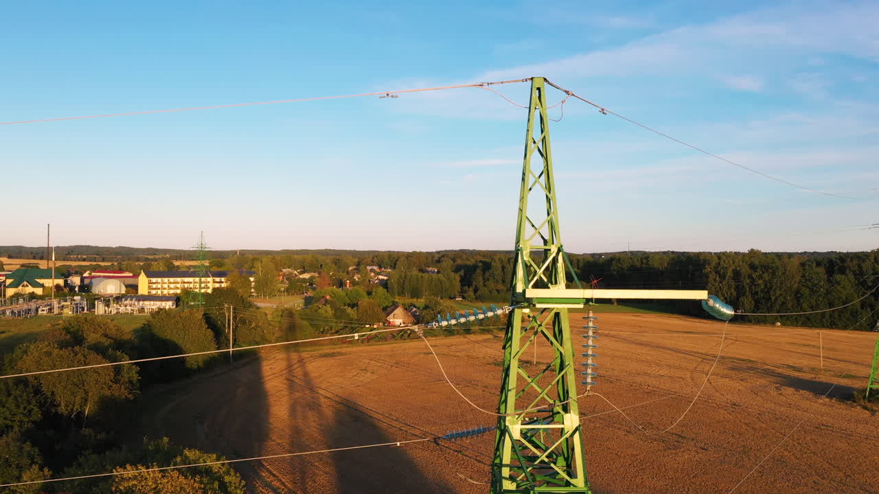 Transmission Tower With Rural Fields In The Background During Sunset