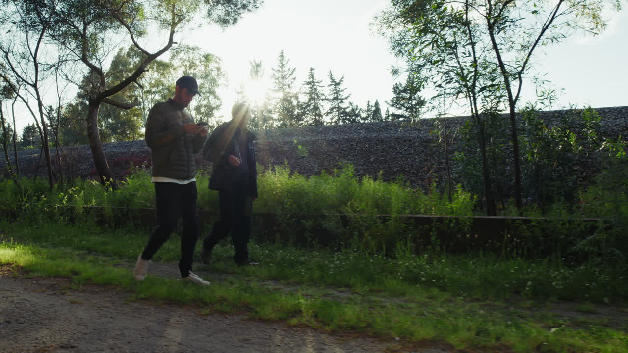 Elderly Father Walks in Park with Son at Sunset