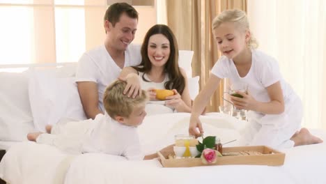 Family-having-healthy-breakfast-in-bed