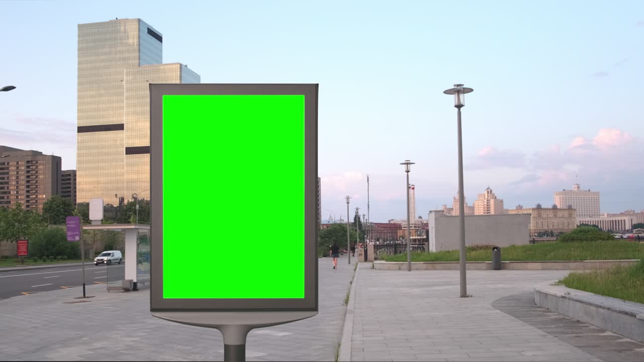 Empty billboard with a green screen for advertising in the beautiful street, sunny shot