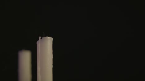 Two-white-Candles-lit-and-running-in-some-wind-and-get-blown-out