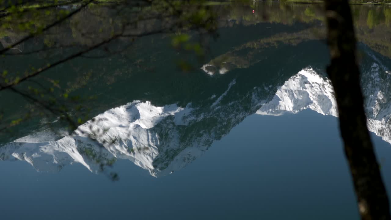 Close up on the reflection of snow capped mountains mirroring on Lake Génos-Loudenvielle in the French Pyrenees.