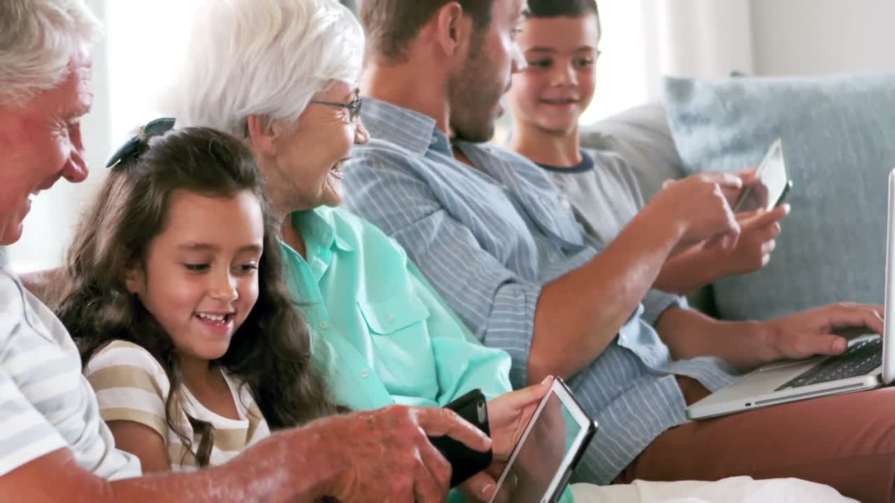 familia linda usando dispositivos electrónicos en el sofá
