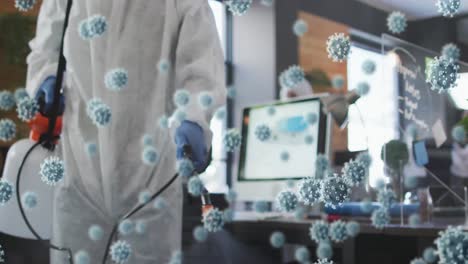 multiple covid-19 cells floating against male health worker spraying disinfectant at office