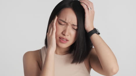 asian woman showing headache on camera.