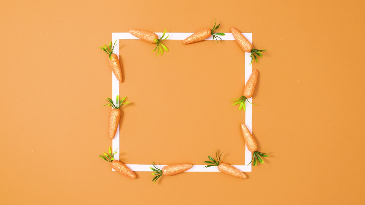 오렌지색 배경에 움직이는 당근과 함께 색 공간 프레임을 복사합니다. 움직임을 멈추십시오.