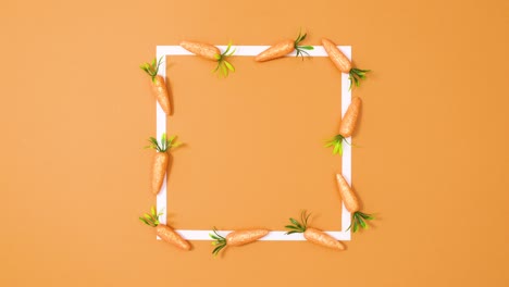 copia el marco espacial blanco con zanahorias en movimiento en fondo naranja. detenga el movimiento