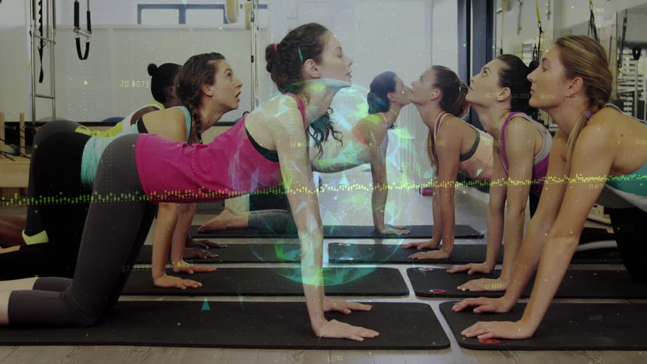 Group of women practicing yoga in fitness studio, with floating data overlays and rotating globe