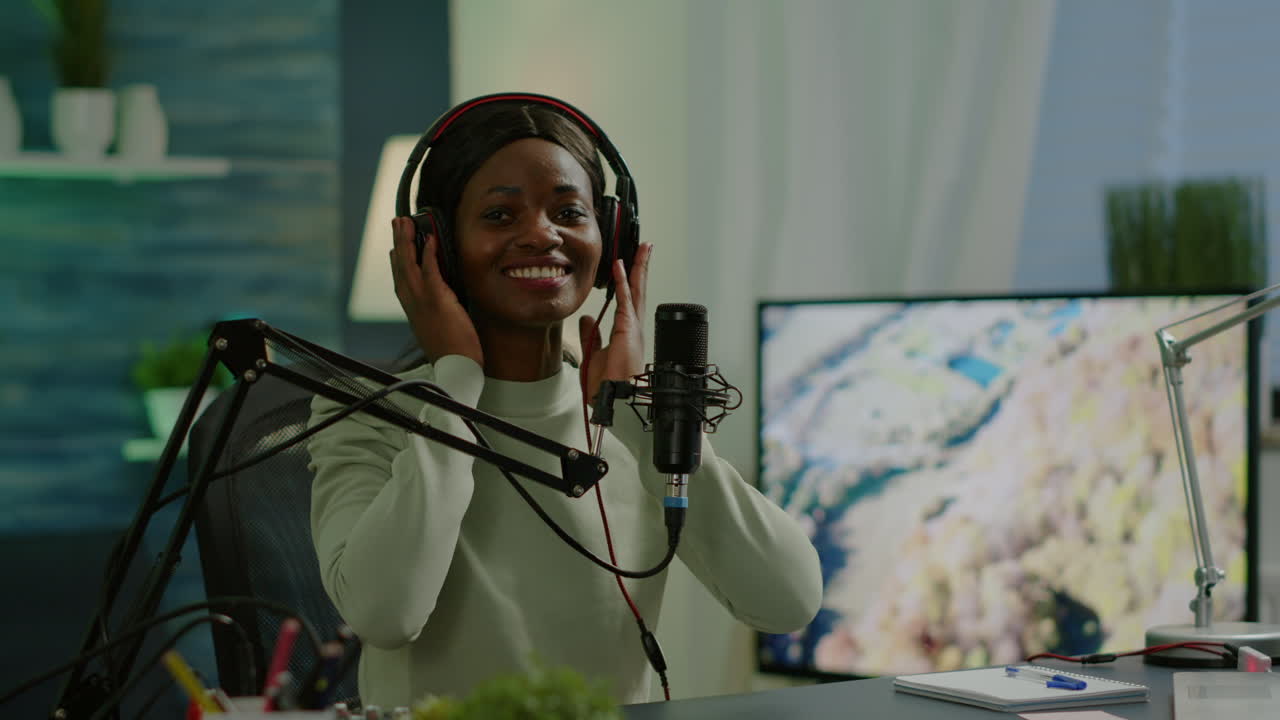 African blogger smiling at audience while filming podcast