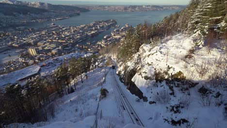 still shot ferrocarril funicular fløybanen subiendo las colinas hasta el monte fløyen - escena invernal de la ciudad de bergen