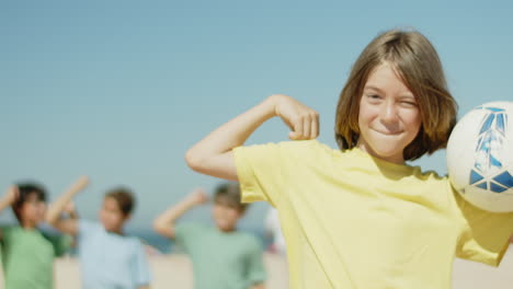 happy boy holding soccer ball and bending arm at elbow