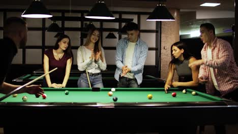 friends joyfully play billiards