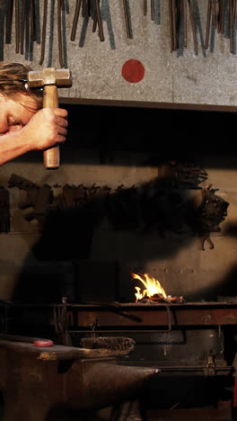 herrero trabajando en una barra de hierro
