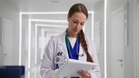 doctor writing notes in hospital corridor