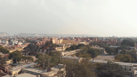 Colourful-skyline-view-of-Jaipur-cityscape-on-a-foggy-sunny-morning-in-Rajasthan,-India---Aerial-Slide-Fly-over-showcase-shot